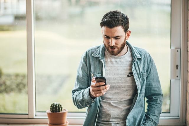 Håller mobiltelefon